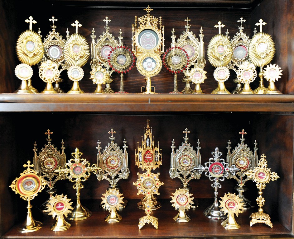 INSPIRATION AND HOPE—Relics are reverently displayed in gleaming reliquaries. Father Carrella bought a reliquary to house each relic in his collection; each is identified. He said that relics remind the faithful of their connection to the saints, who, like them, struggled to practice virtue, won the battle and attained heaven, and now intercede for those on earth.