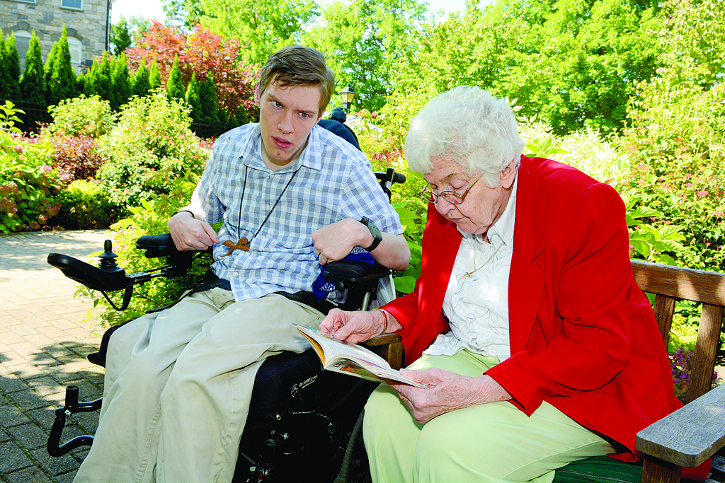 SPECIAL MINISTRY—Neil Burke, a Dominican Associate who volunteers with the Dominican Sisters of Hope, listens to Sister Jorene Cieciuch, O.P., read from Scripture on a beautiful summer’s day outside Wartburg assisted living facility in Mount Vernon.