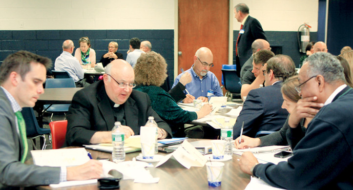 IMPORTANT DISCUSSION-Msgr. Leslie Ivers, pastor of Epiphany parish in Manhattan, speaks with three members of the parish's core team during a training session for the Manhattan East Vicariate at Cathedral High School Sept. 25.  Joining Msgr. Ivers were parishioners John Molenda, Walter Adams and Debbie Keogh.