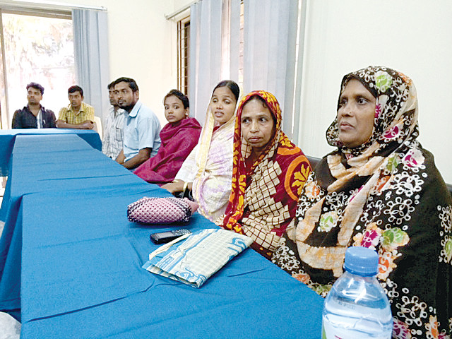 TESTIFYING—Workers and their loved ones talk to a delegation from New York about the Rana Plaza building collapse last year in Bangladesh. The delegation, including Msgr. Kevin Sullivan, executive director of Catholic Charities, was in Dhaka, Bangladesh, to learn about measures taken since the collapse to improve workers’ safety and working conditions.