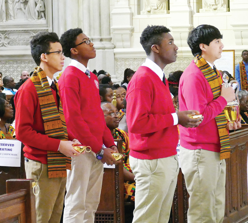 La Salle Academy students, from left, Jayden McCoy, David Goudet Turner, Rohan Tucker and Joseph Palaguachi bring forward the offertory gifts.