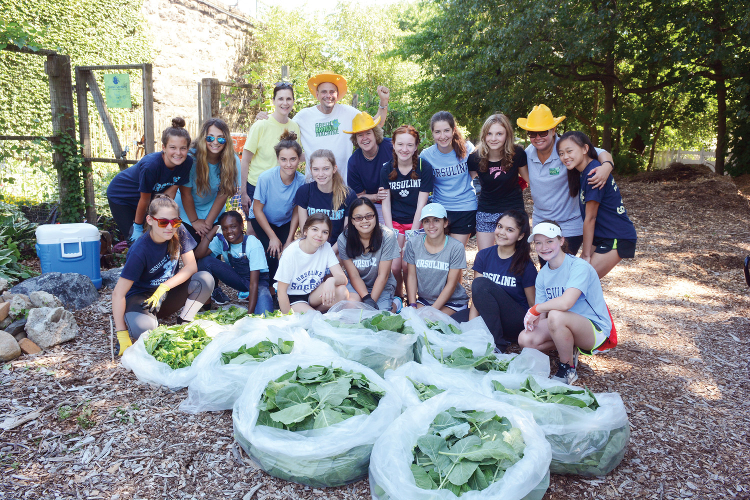 Fifteen students from The Ursuline School in New Rochelle, joined by their new principal, Rosemary Beirne, navy blue shirt and golden hat, reap what they sowed at the Food for Others Garden in the Wakefield section of the Bronx July 10. Students filled bags with collard greens, basil and jalapeno peppers.