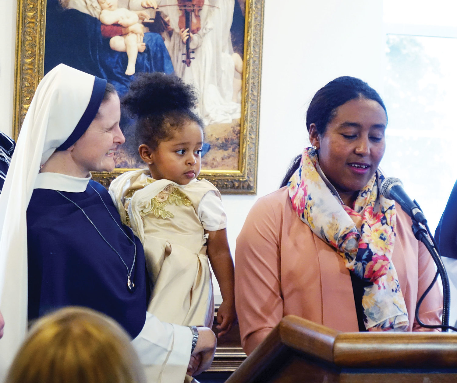 MOM’S BIGGEST FAN—Sister Maeve Nativitas, S.V., holds young Sena Love, as her mother, Brhane, speaks during a Feb. 18 press conference in which Cardinal Dolan and others confirmed the archdiocese’s commitment to helping pregnant mothers in need.