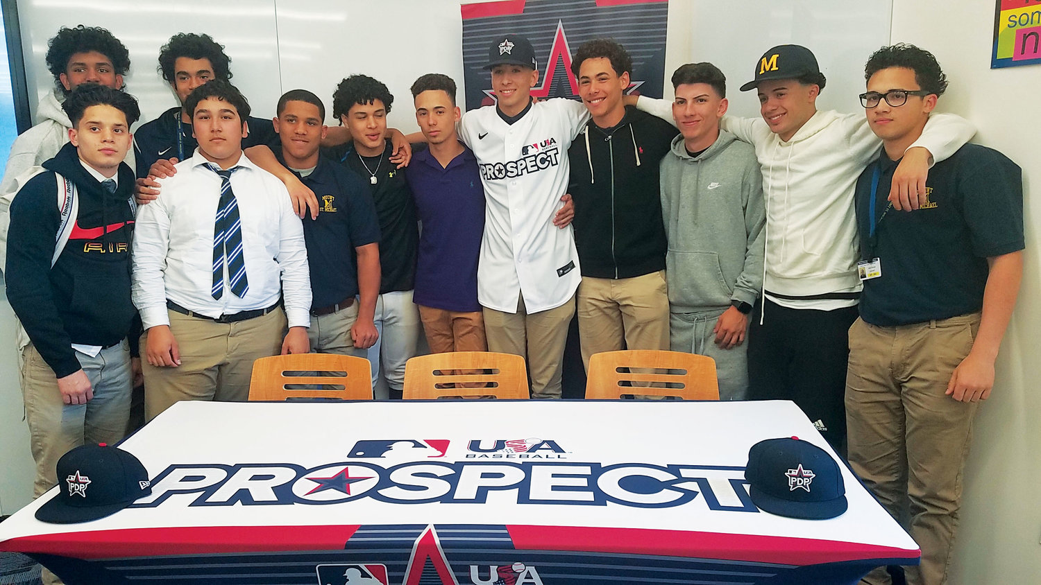 OFF TO CAMP—Alex Santos, center, joins his Mount St. Michael Academy teammates after being presented his jersey and cap for the inaugural Prospect Development Pipeline League in a ceremony May 16 at the Bronx school.