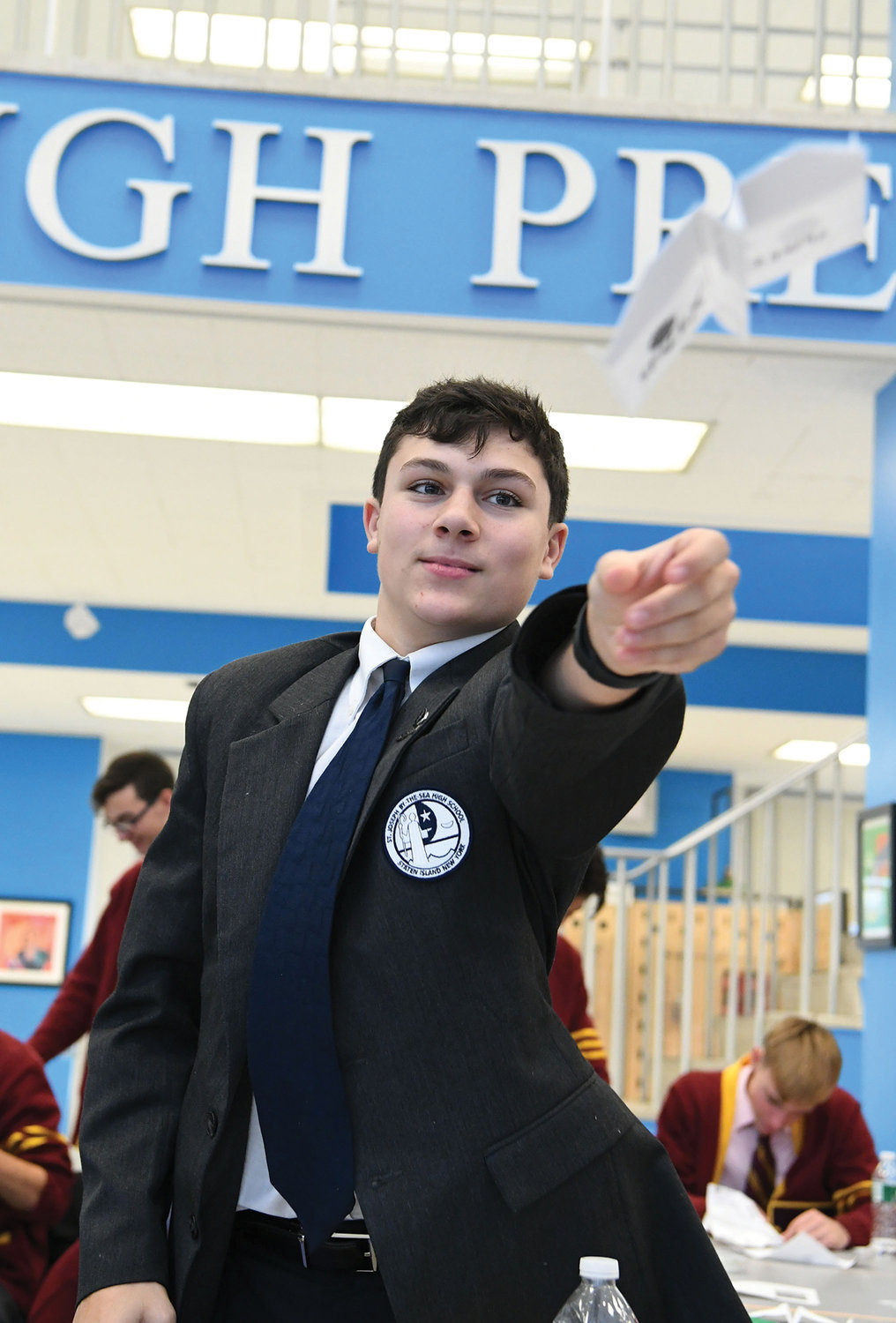 Frank Falcone, a student at St. Joseph by-the-Sea, sends his paper airplane soaring on a test flight.