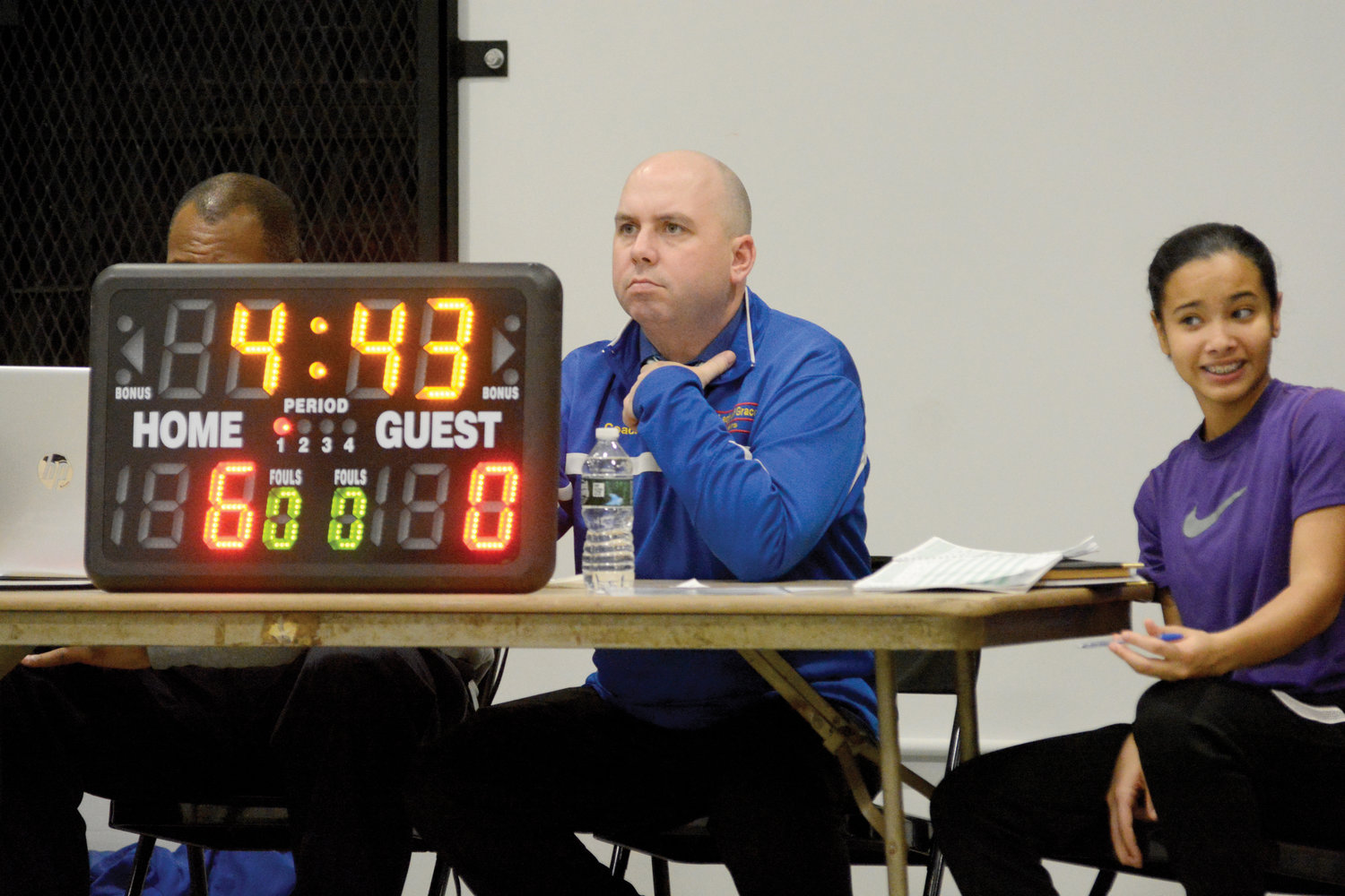Principal Rich Helmrich operates the scoreboard at the scorer’s table.