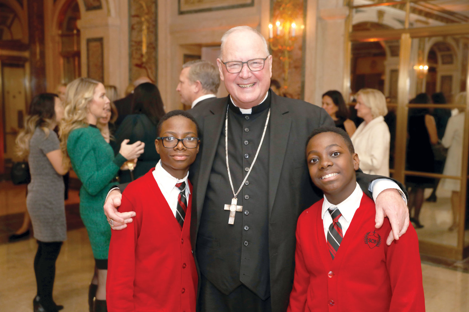 Prince Pierre, left, and Schneider Pierre greet Cardinal Dolan at the 43rd annual Inner-City Scholarship Fund Awards Dinner at the Plaza Hotel in Manhattan last December. The Pierre brothers, who are Inner-City Scholarship Fund recipients, attend St. Charles Borromeo School in Harlem.