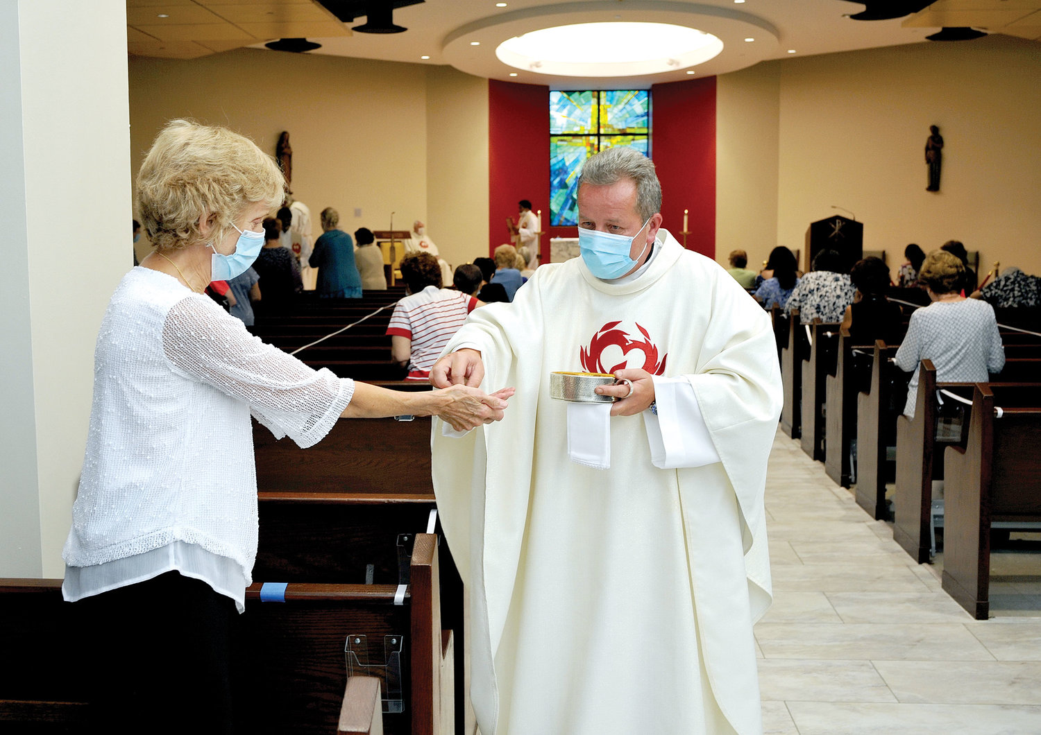Father Vladimir Chripko, C.O., pastor of St. Paul-St. Ann parish and provost of the New York Oratory of St. Philip Neri, distributes Communion at a Mass celebrating the reopening of the renovated St. Paul’s Church in Congers Aug. 8.
Father Chripko also went outside to distribute the
Eucharist to the 50 people celebrating the Mass
outdoors as only 150 parishioners were permitted in
the 1,200-seat church due to social distancing as a
result of the coronavirus pandemic.