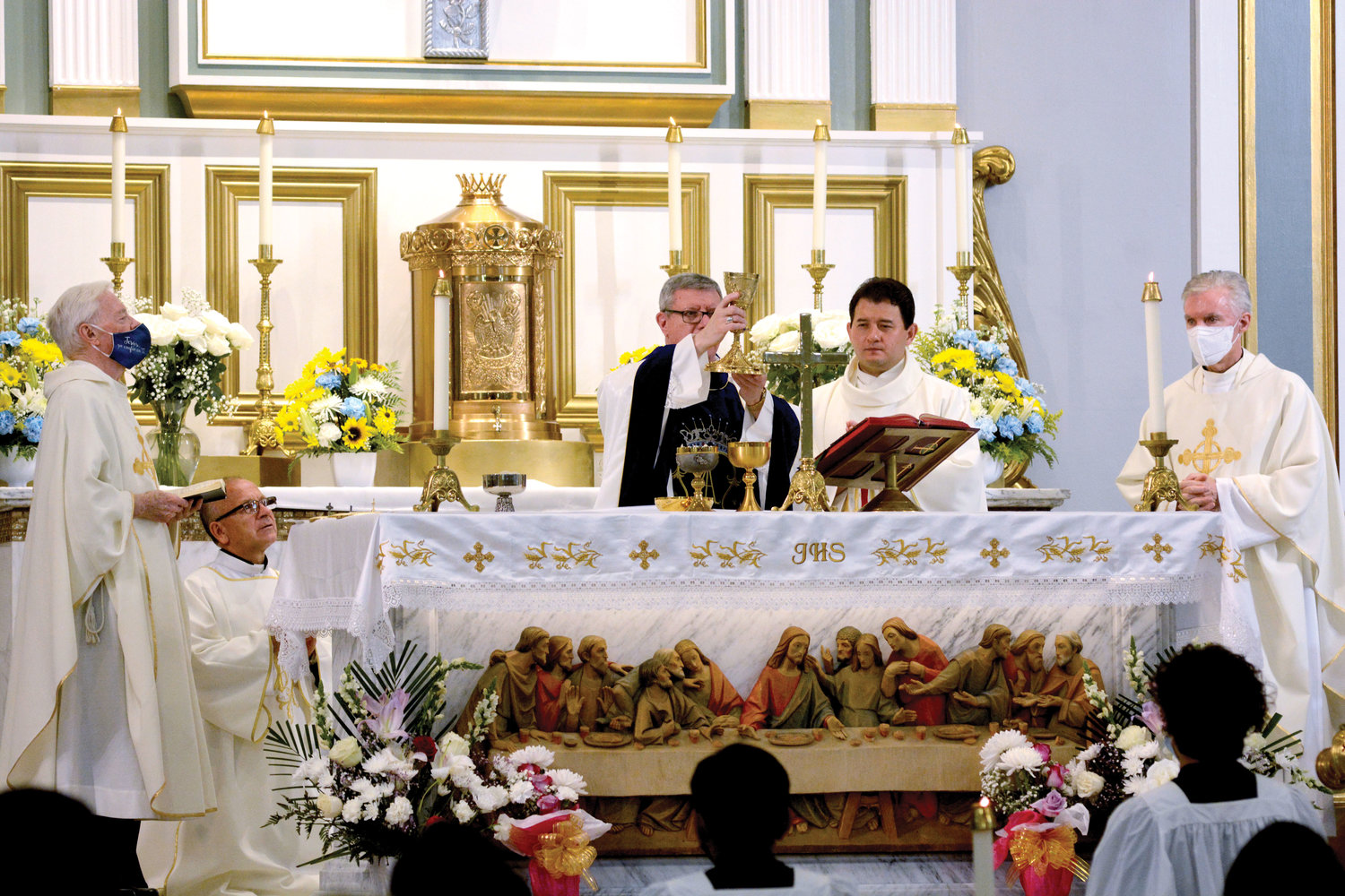 SACRED MOMENT—Auxiliary Bishop Gerardo J. Colacicco lifts the chalice during the consecration at the Vigil Mass for the feast of the Assumption of the Blessed Virgin Mary Aug. 14 at Assumption parish in Peekskill. On the altar with the bishop are, from left,
Father Richard Albertine, M.M., Deacon Carlos Campoverde (kneeling), Father Carlos Limongi, parochial vicar of Assumption, and Father Timothy Kilkelly, M.M. Right.