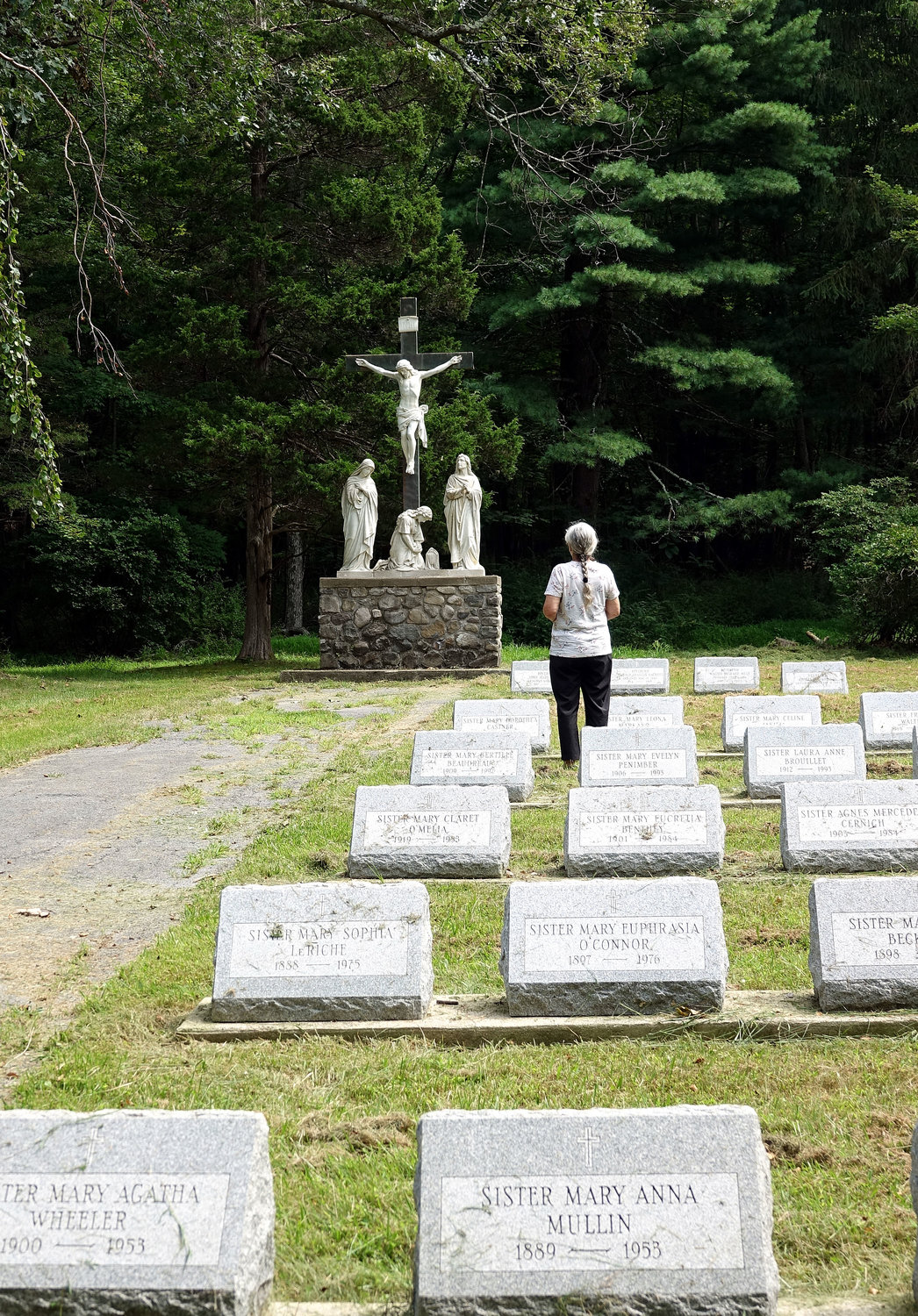 A visitor prays in the sisters’ cemetery at Marycrest, located on more than 100 acres of land in Orange County.