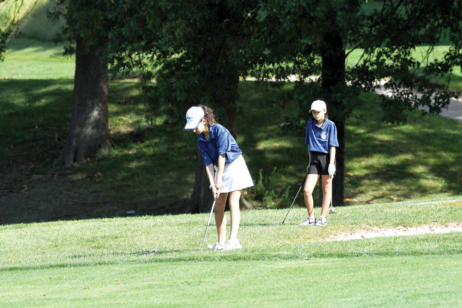 Isabella Sheikowitz chips to the second hole during the Dr. Theodore A. Atlas CYO Junior Golf Tournament at Silver Lake Golf Course on Staten Island Sept. 3. Watching her was Abby Garcia, who was the overall girls winner at the tournament.