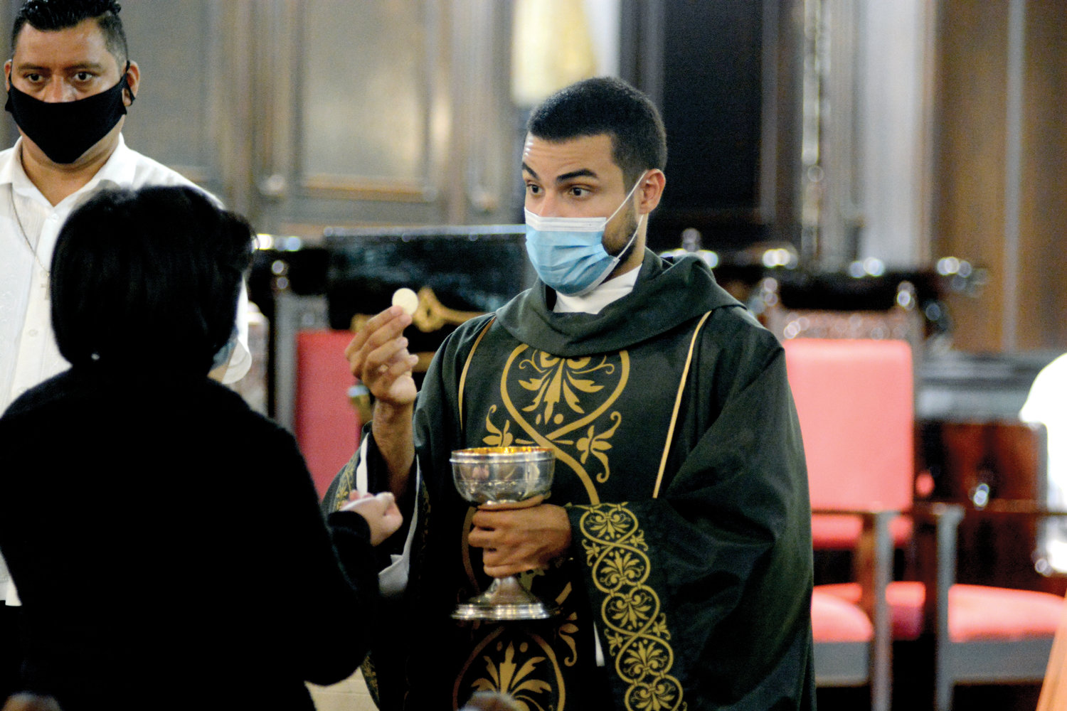 El padre Orlando Rodríguez Jr., Sch. P., distribuye la eucaristía durante una misa matutina celebrada el 13 de septiembre en la parroquia de la Anunciación en West Harlem.