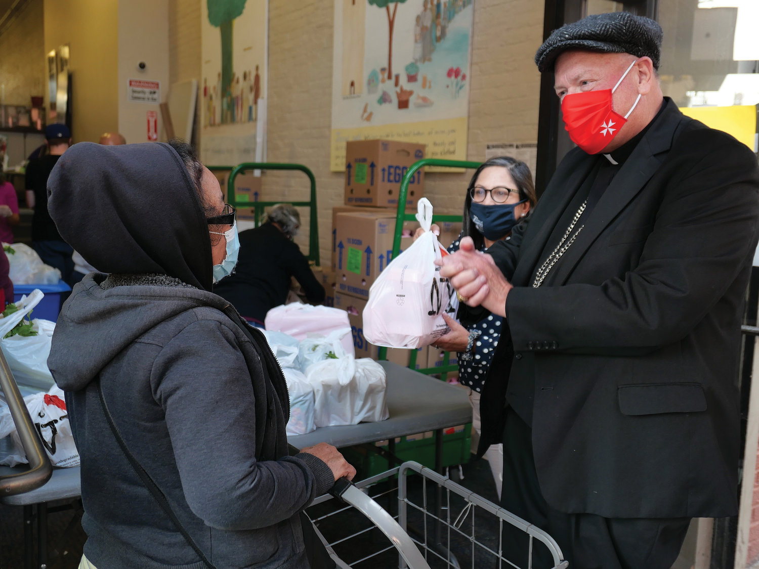 Cardinal Dolan helps to hand out bags of food during a Sept. 23 Catholic Charities food distribution event at its site on East 152nd Street in the Bronx.