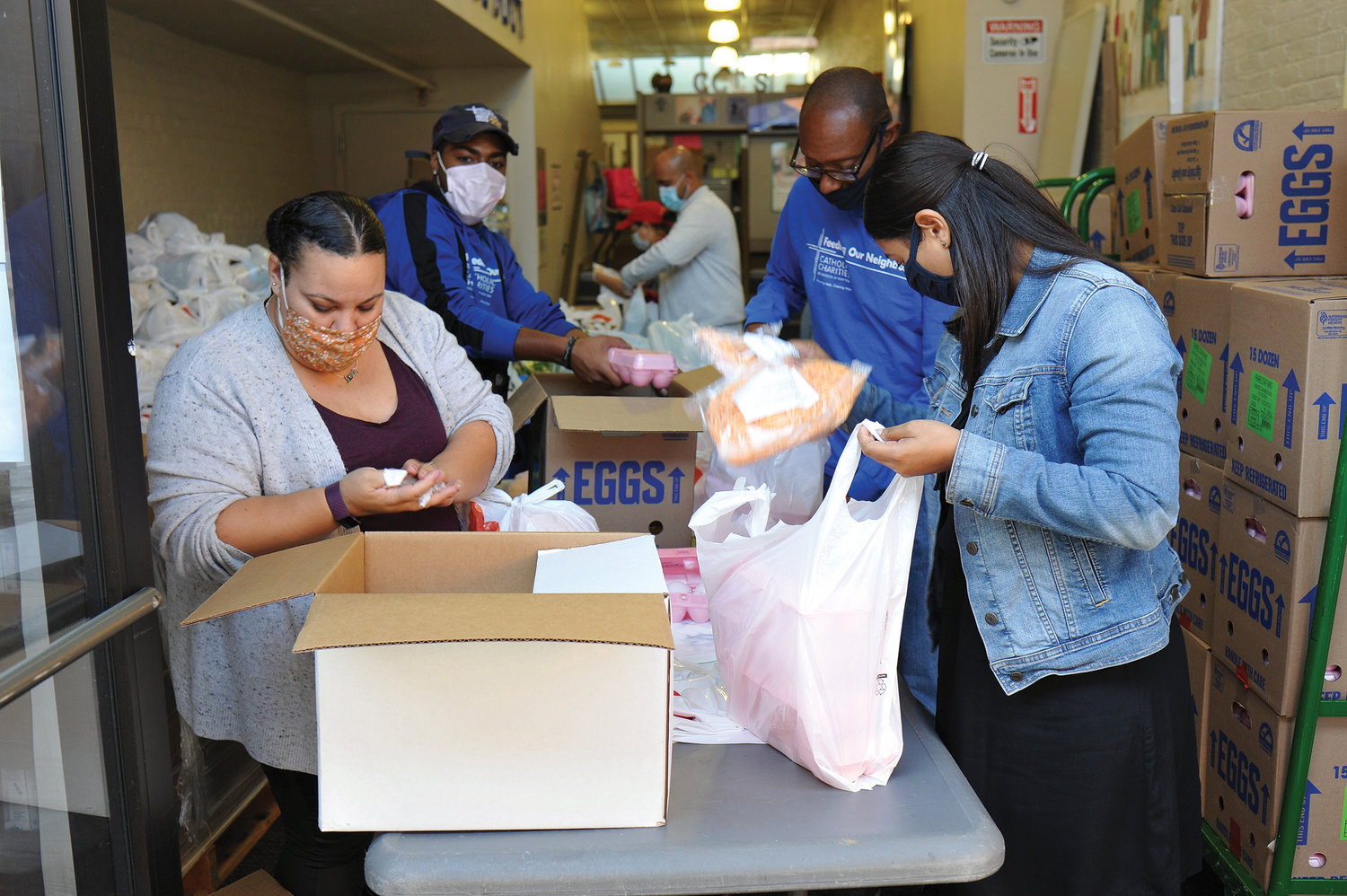 Staff and volunteers prepare the bags of food for distribution. Since the beginning of the coronavirus pandemic in March, Catholic Charities has distributed 1 million meals, more than double the number it has provided during the same period in recent years.