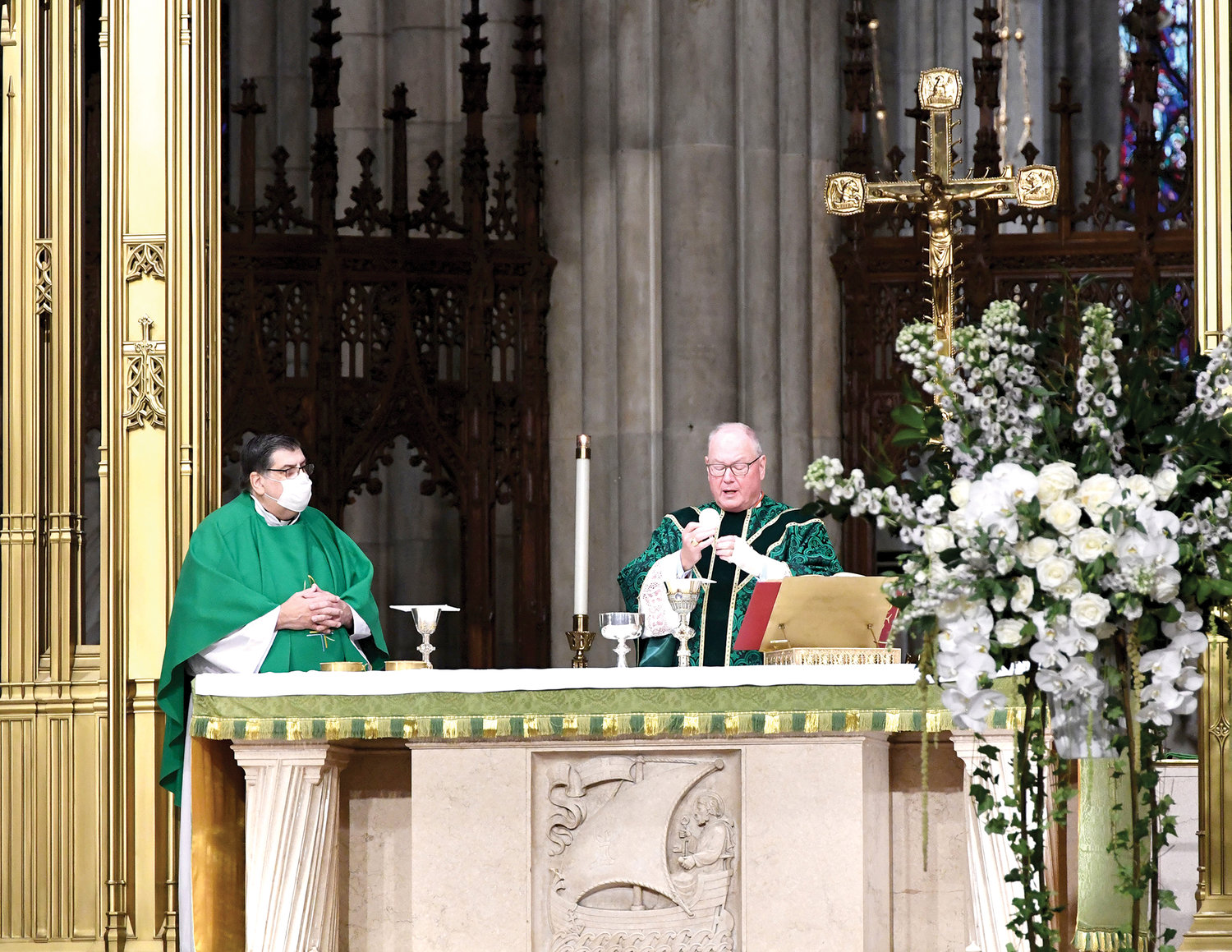 Cardinal Dolan consecrates the Eucharist during the World Mission Sunday Mass at St. Patrick’s Cathedral Oct. 18. With the cardinal is Msgr. Marc Filacchione, director of the archdiocesan Society for the Propagation of the Faith.