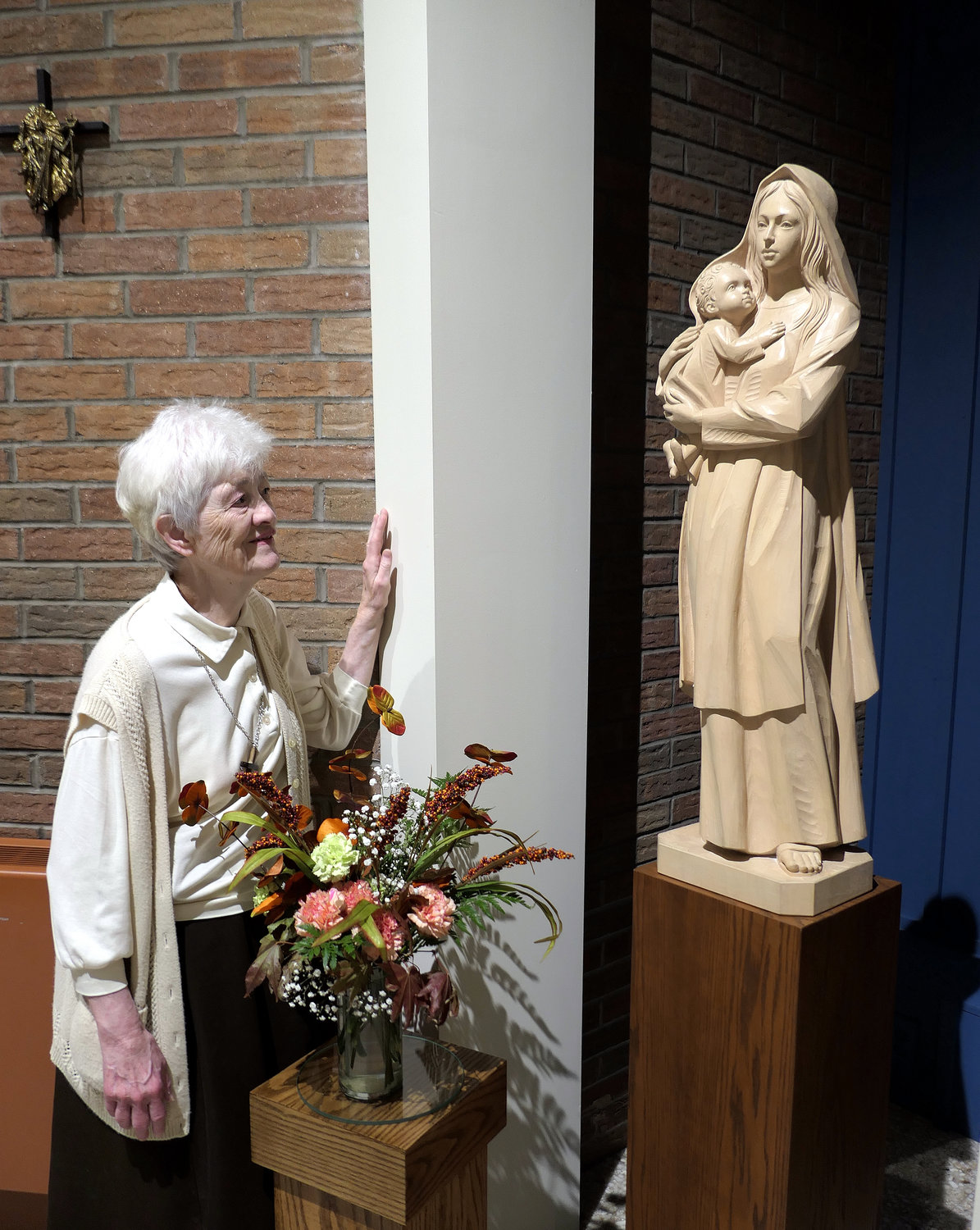 Sister Michaelene Devine, O.C.D., prioress, contemplates before a statue of Our Lady of Mount Carmel inside the chapel. This year the nuns are celebrating the 100th anniversary of the arrival of their order in the Archdiocese of New York.