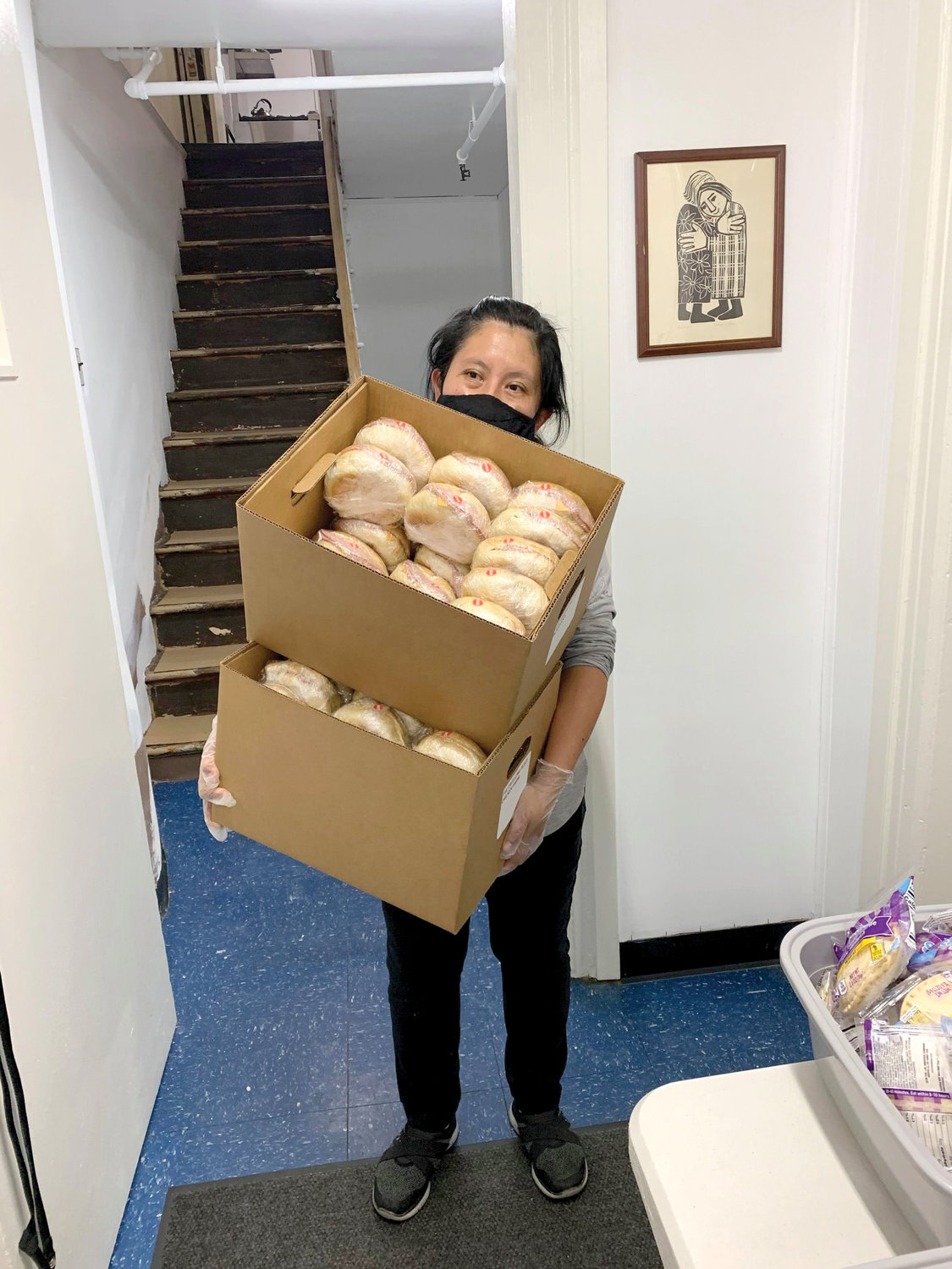 COMMUNITY DINNER—Luisa Mendez-Vega, a 20-year staff member of The Dwelling Place of New York, carries boxes of sandwiches for distribution at a Wednesday take-out dinner for former residents as well as members of the local community. The Manhattan women’s shelter, which was forced to temporarily shut its doors in June, is planning to reopen in early January.