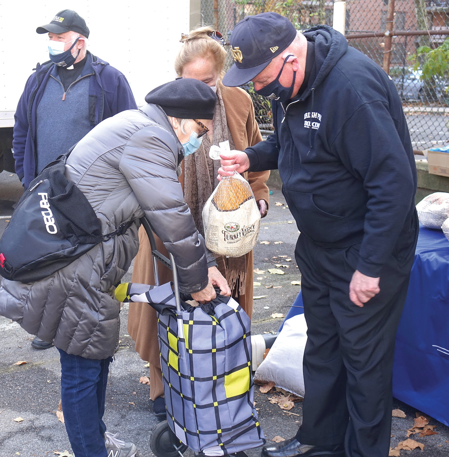 THANKSGIVING BLESSING—Cardinal Dolan was present to distribute some of the 500 turkeys given away Nov. 24 outside the Lt. Joseph P. Kennedy Community Center in Harlem. Also distributed with each turkey were a selection of other foods, including rice, beans and stuffing. The gathering was organized by archdiocesan Catholic Charities.