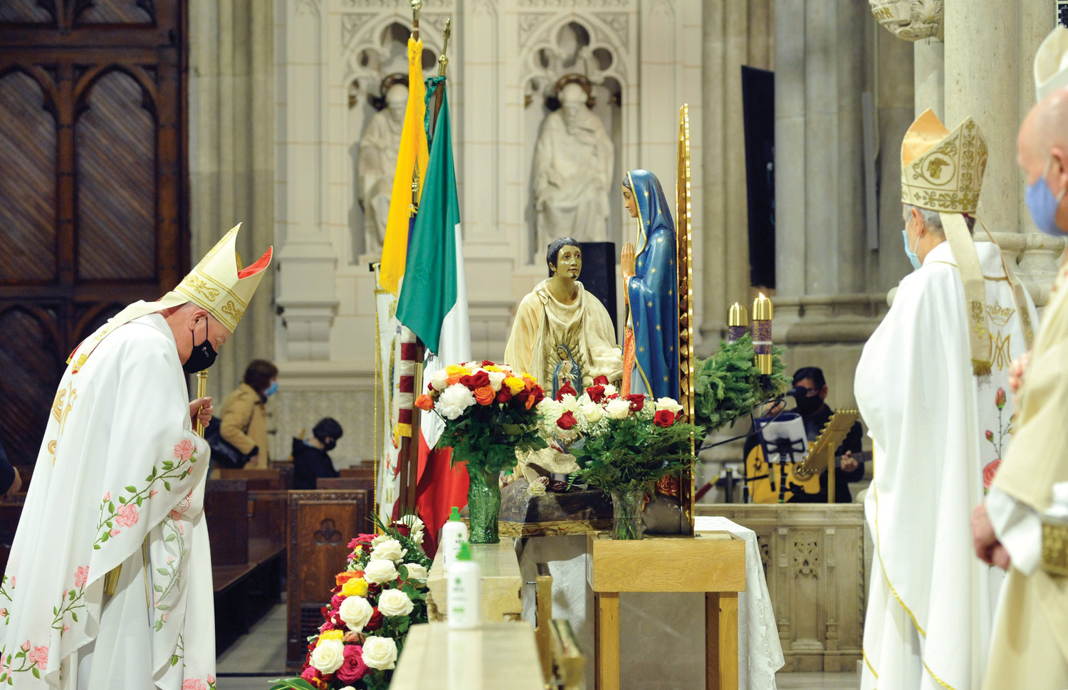 Cardinal Dolan prays at a statue of Our Lady of Guadalupe Dec. 12 before the annual feast-day Mass for the patroness of the Americas at St. Patrick’s Cathedral. At right is Archbishop Gabriele Caccia, Vatican nuncio to the United Nations, who served as a concelebrant.