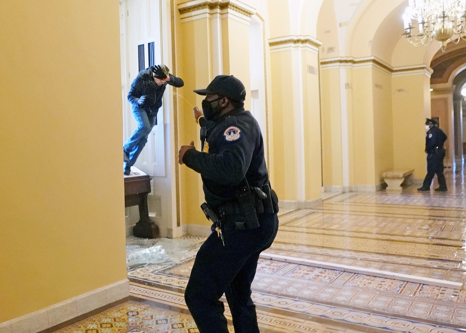 BREAKING IN—A Capitol police officer shoots pepper spray at a protester attempting to breach the U.S. Capitol building through a window during a joint session of Congress to certify the 2020 election results on Capitol Hill in Washington Jan. 6.