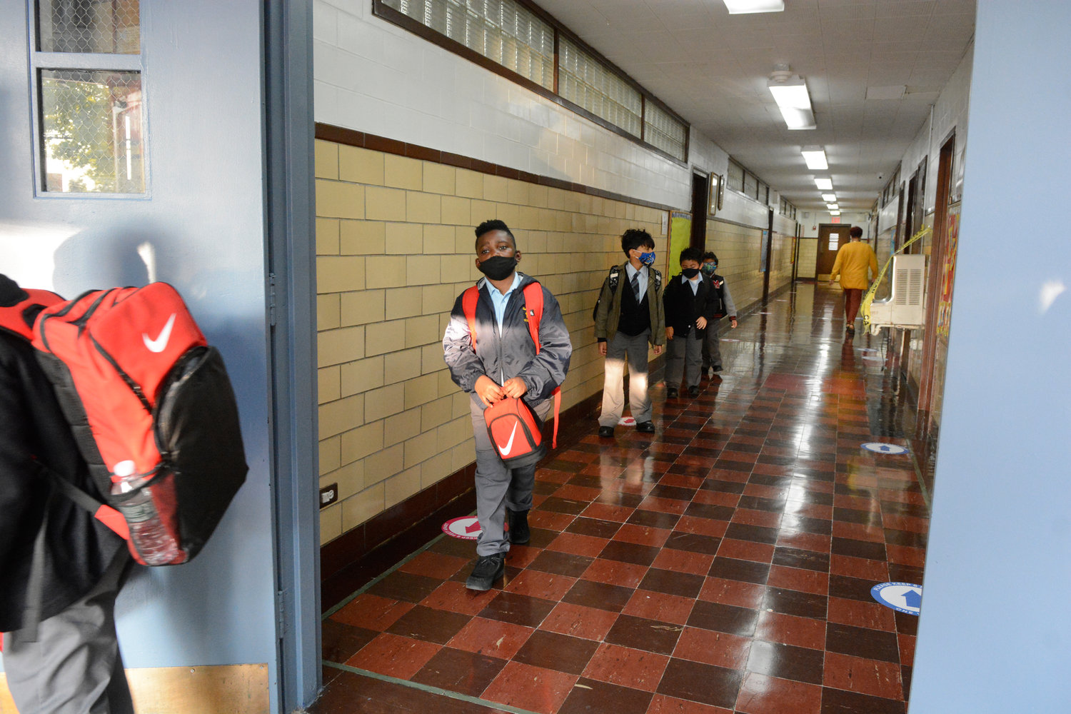Students, donning face masks, maintain social distance amid the coronavirus pandemic as they report to Our Lady of Grace School, the Bronx, last September.