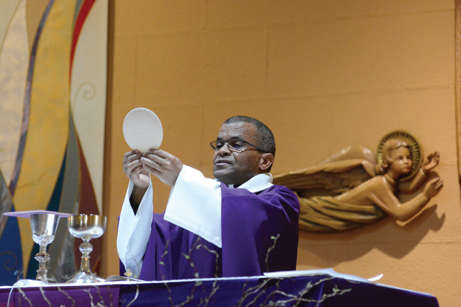 Father Ricardo Fajardo, pastor since 2010, elevates the Eucharist.