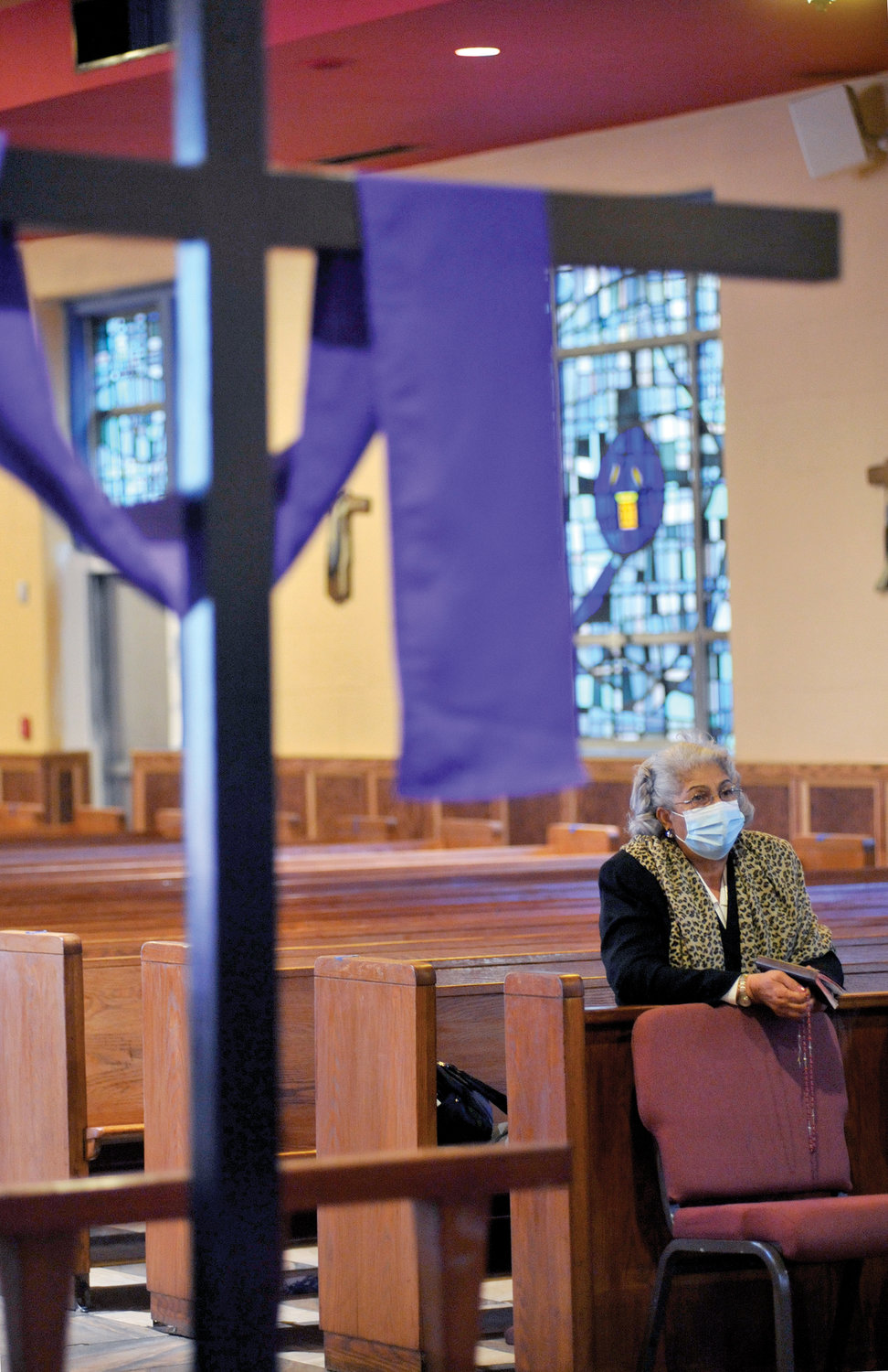 A purple cloth drapes a cross in the front of the church for the Lenten season.