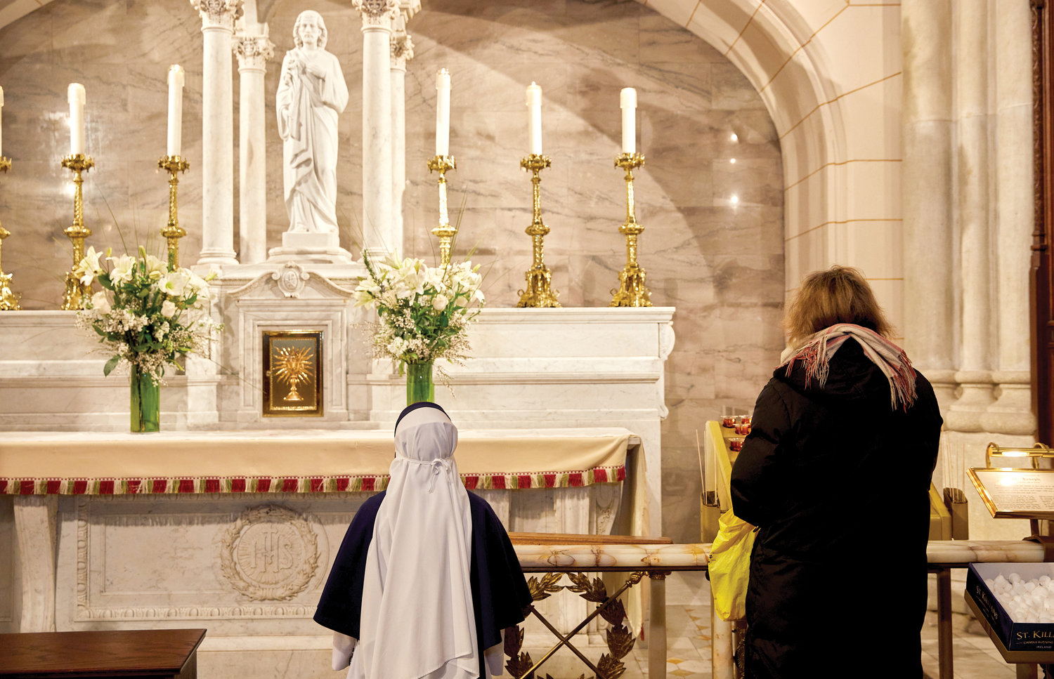 A Sister of Life kneels before the statue of St. Joseph that graces the side altar of the saint at St. Patrick’s Cathedral March 19. Cardinal Dolan had just consecrated the Archdiocese to St. Joseph following the 7 a.m. Mass he offered at the cathedral’s main altar.