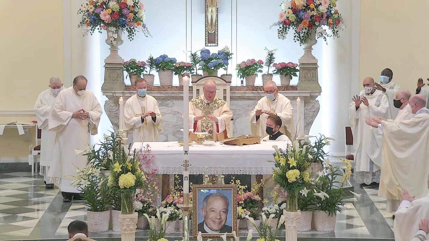 A picture of the late Msgr. Richard Guastella graces the sanctuary of St. Clare Church on Staten Island at a Memorial Mass Cardinal Dolan celebrated April 9. To the left of the cardinal is Auxiliary Bishop Edmund Whalen, and at the cardinal’s right is Retired Auxiliary Bishop John O’Hara. Msgr. Guastella served as pastor of St. Clare’s from 2008 until his death last year. He was also pastor of Holy Rosary parish on Staten Island, 1987-2008.