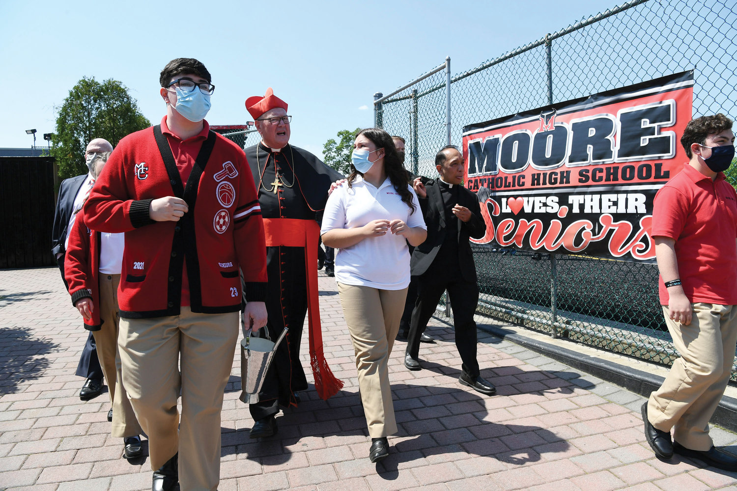 Cardinal Dolan walks with students following his dedication of the new athletic field at Moore Catholic High School on Staten Island May 17. From front left are John Ardi, Magdalena Bielawski and Luke Curcio. Michael Deegan, superintendent of schools for the archdiocese, is at back left and Father Rhey Garcia, the school chaplain, is back right. The cardinal also blessed the school’s newly refurbished chapel and the repurposed former library which is now the state-of-the-art Student Collaboration Center.