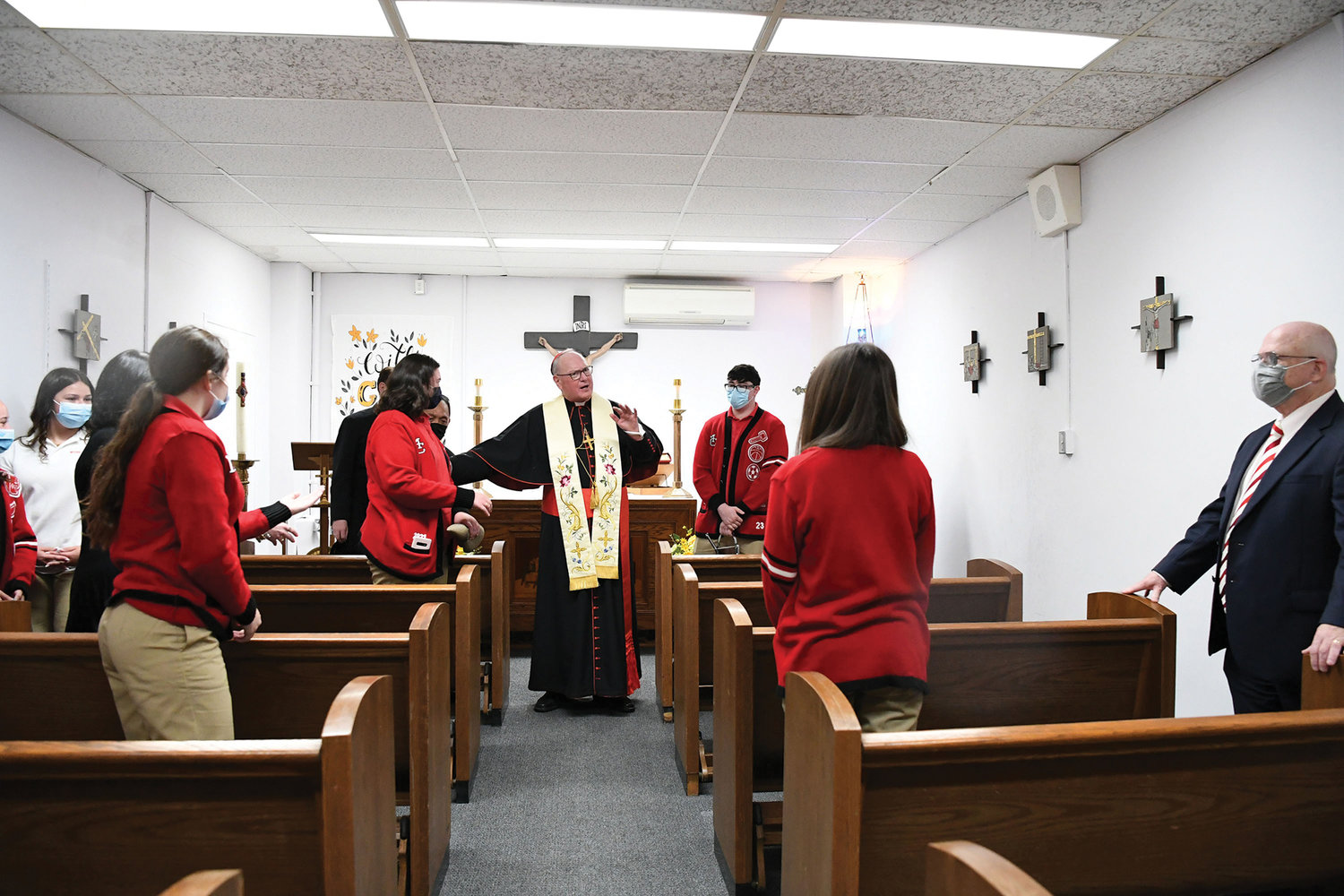 Cardinal Dolan converses with students in the newly refurbished chapel at Moore Catholic High School on Staten Island which he blessed May 17. Michael Deegan, superintendent of schools for the archdiocese, is at far right.