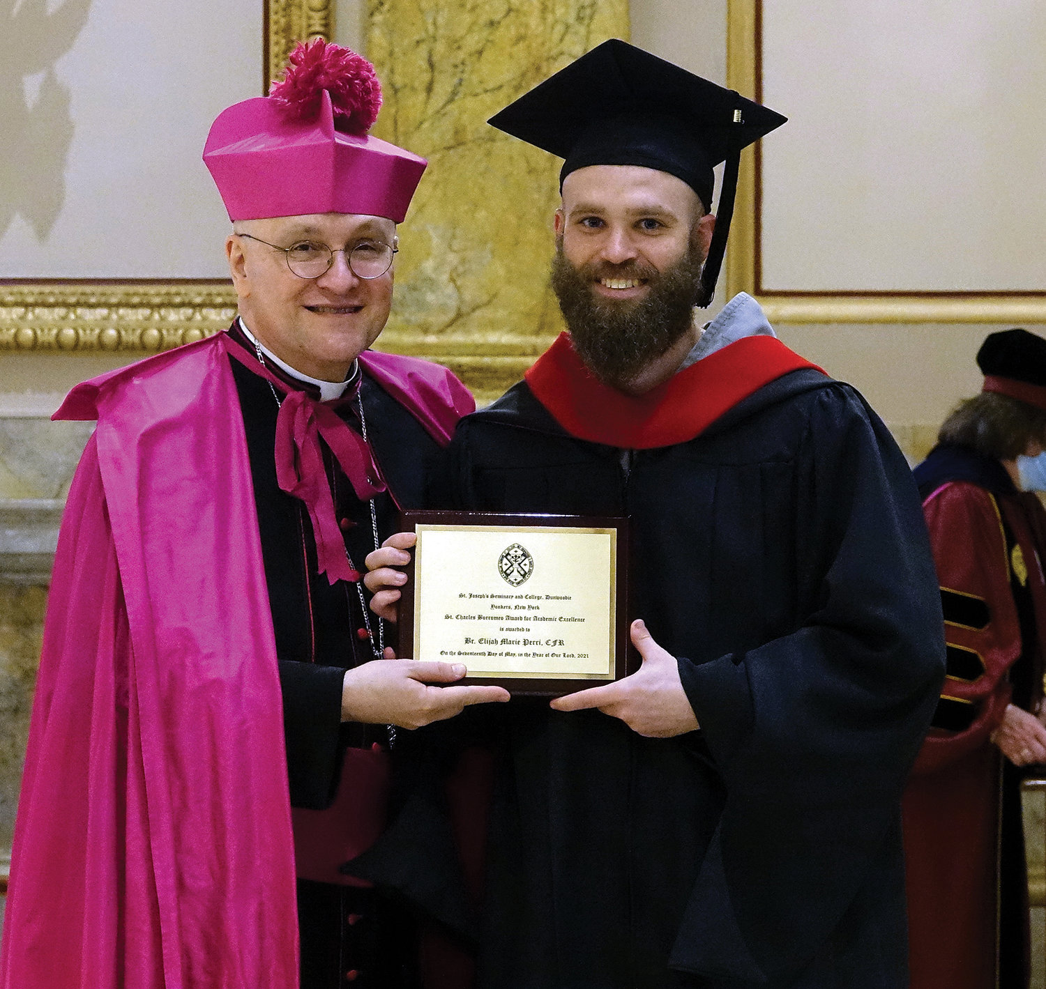 Bishop Massa presents Father Elijah Marie Perri, C.F.R., with the St. Charles Borromeo Award for Academic Excellence.