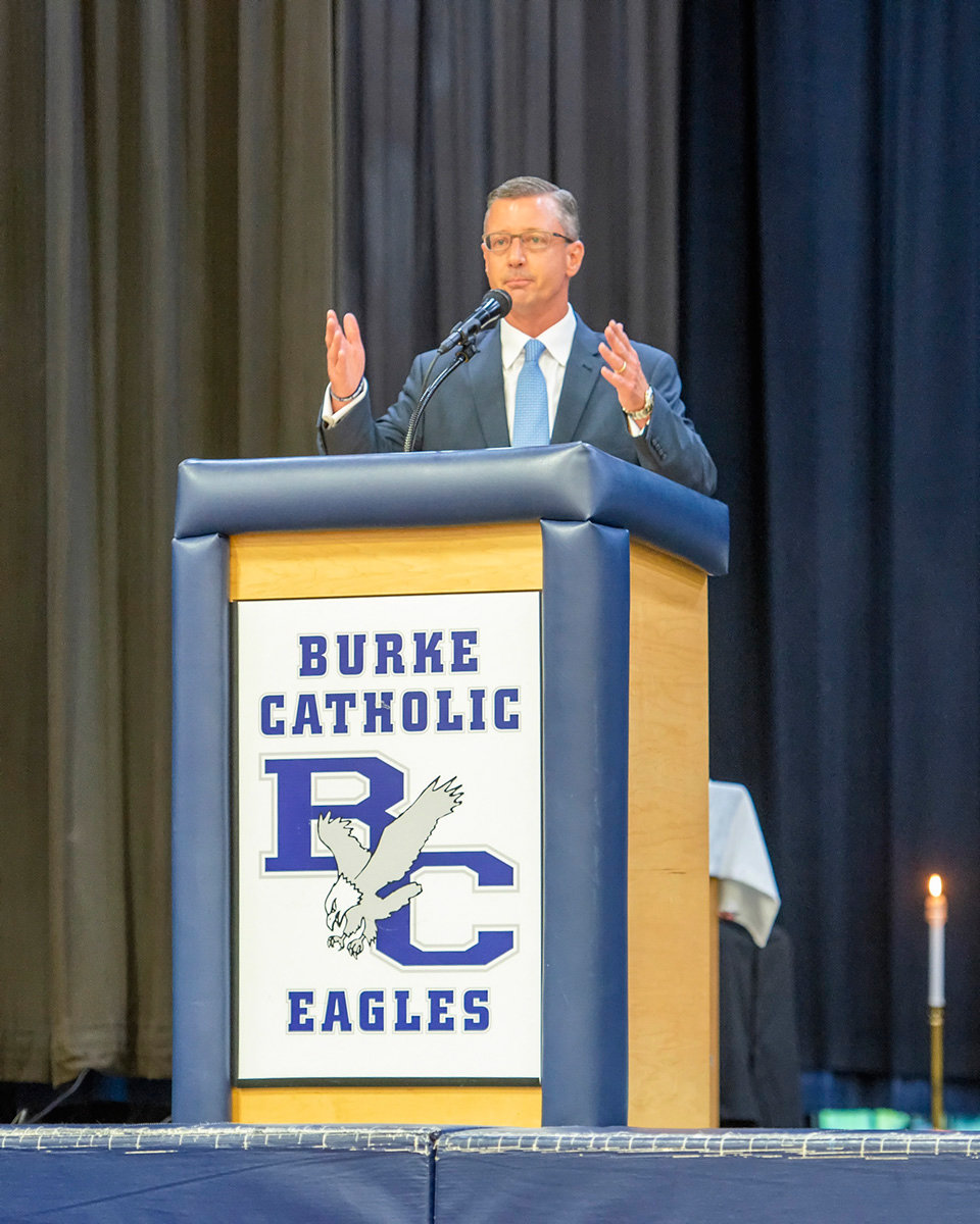 School president John Douthit, a 1986 Burke Catholic graduate, addresses the graduating seniors.