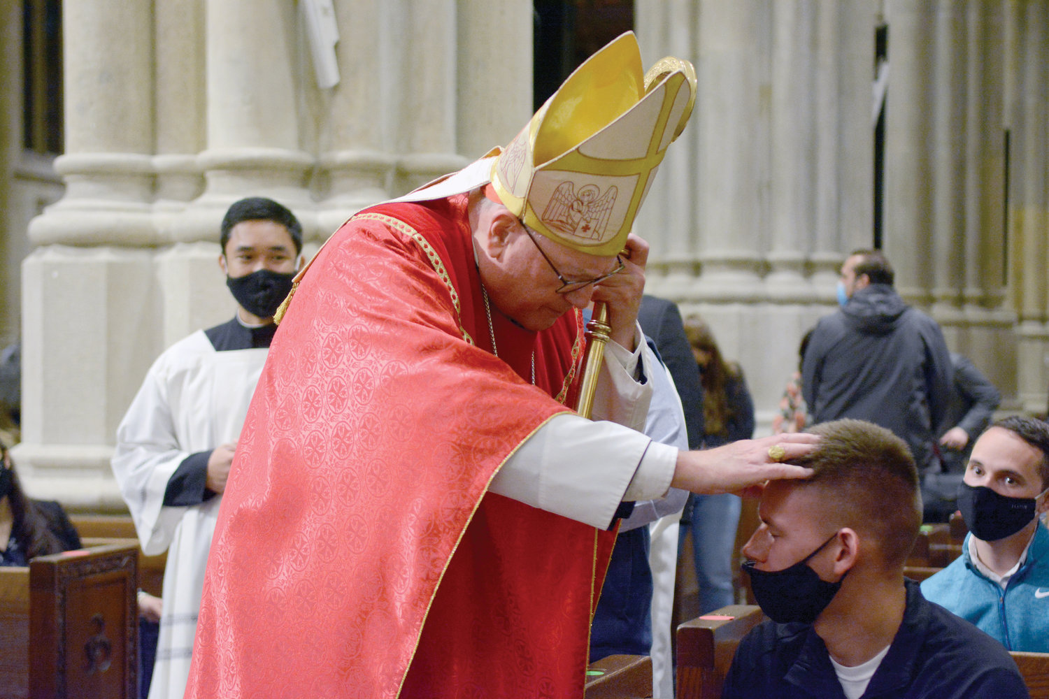 Cardinal Dolan blesses a young man during the evening liturgy. About 400 people attended the Mass, which is organized by the archdiocesan Office of Young Adult Outreach.