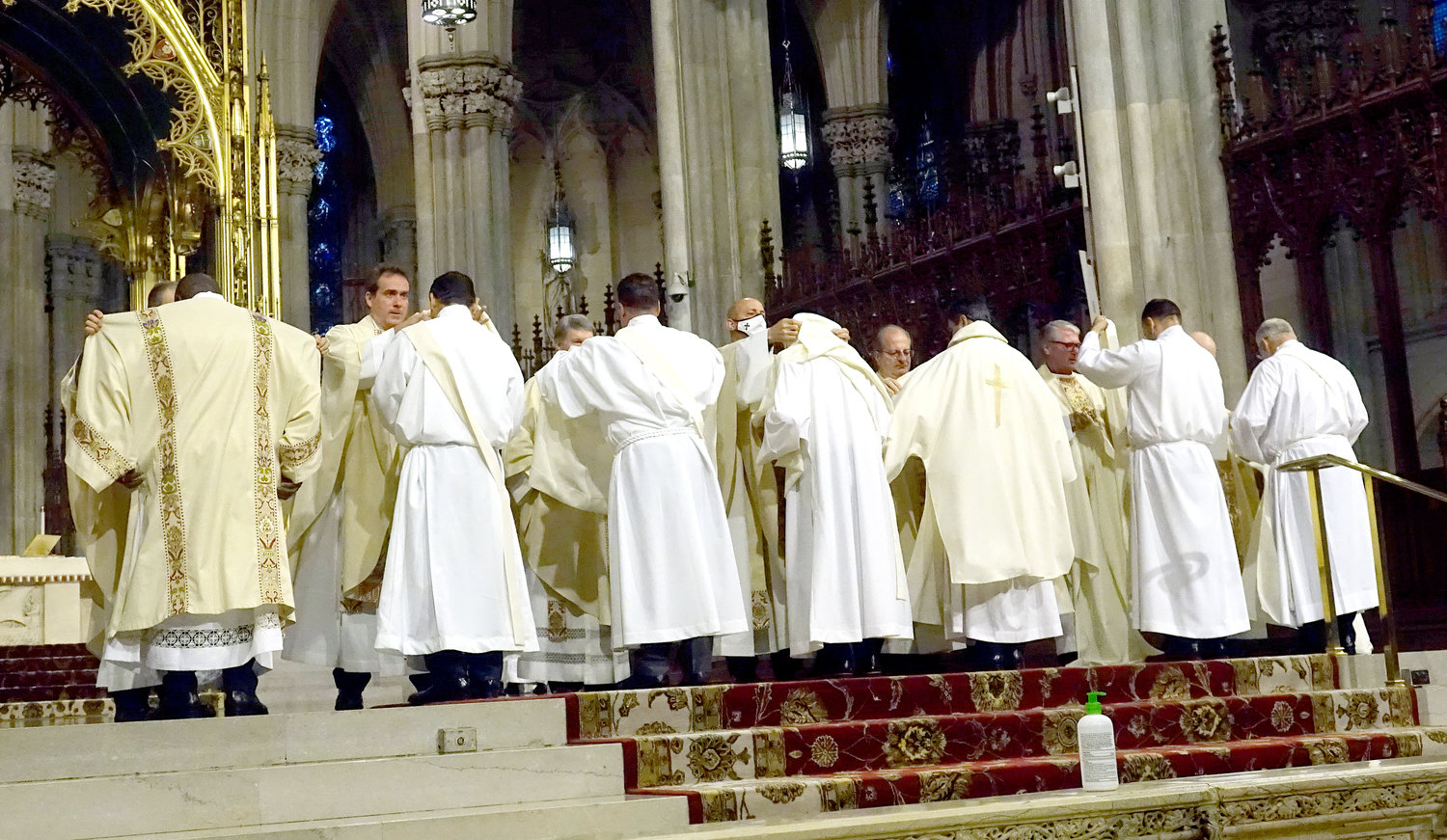 The new deacons are helped with their vestments during the Ordination Rite.