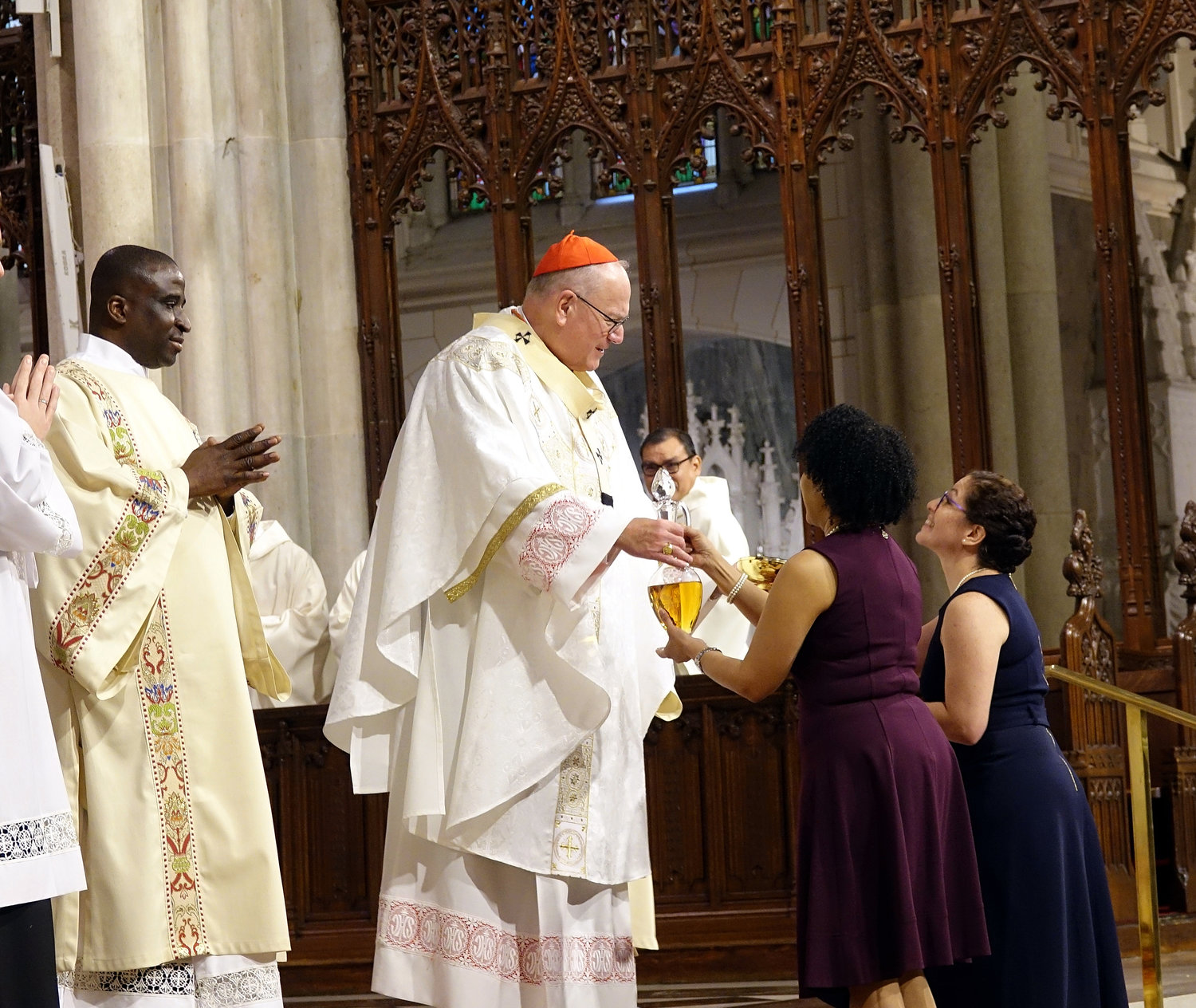 Family members of the new deacons present the offertory gifts to Cardinal Dolan assisted by Deacon Asiamah.