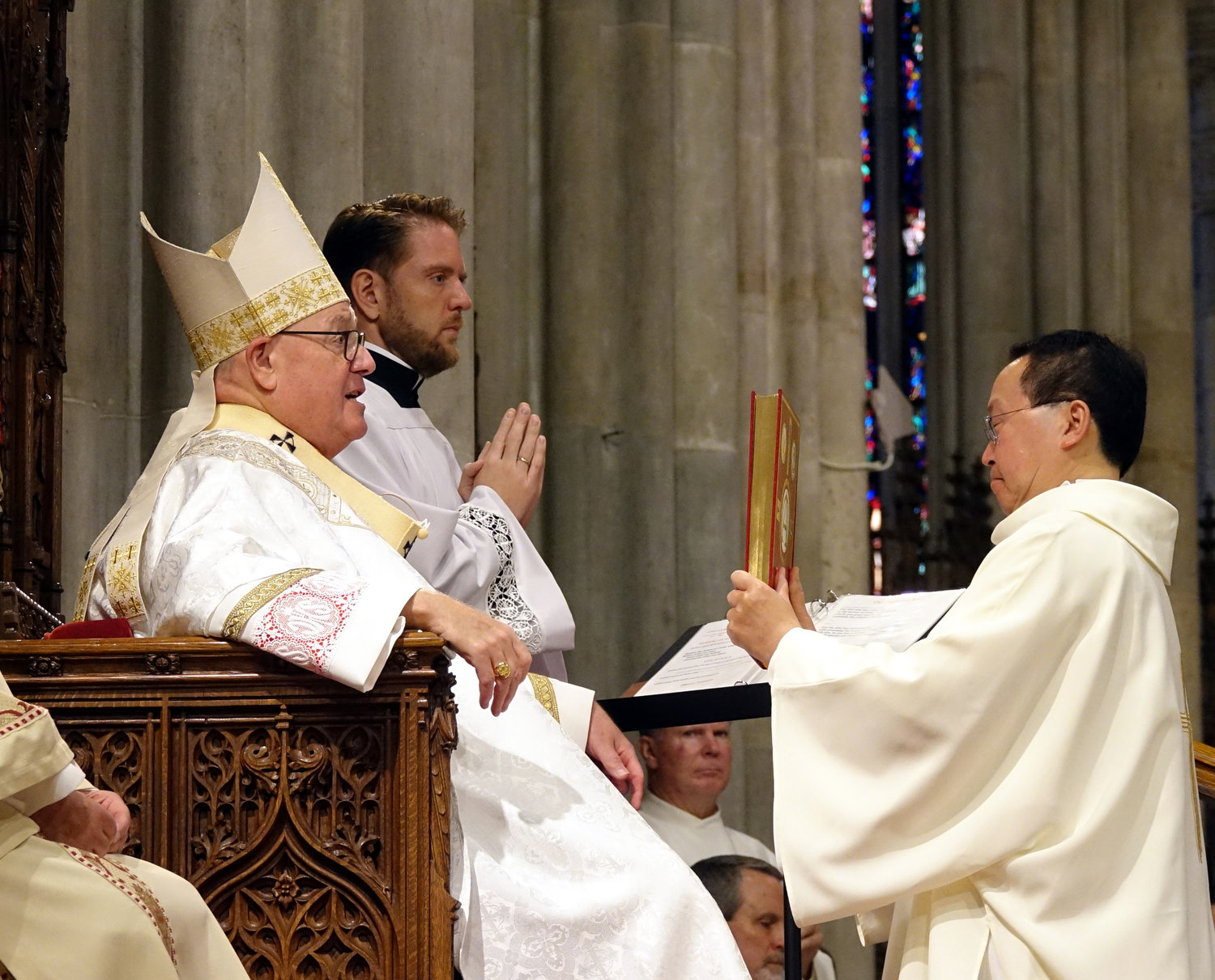 Cardinal Dolan hands Book of the Gospels to Deacon John Hum during the Mass of Ordination in St. Patrick's Cathedral June 19.