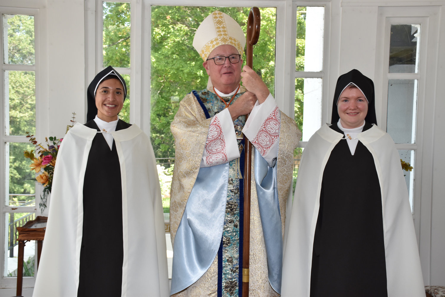 On the day of their first profession, Sister Mary Dolores Carmel, O. Carm., left, and Sister Mary Sharon Rose Carmel Mullin, O. Carm., join Cardinal Dolan at St. Teresa’s Motherhouse in Germantown.
