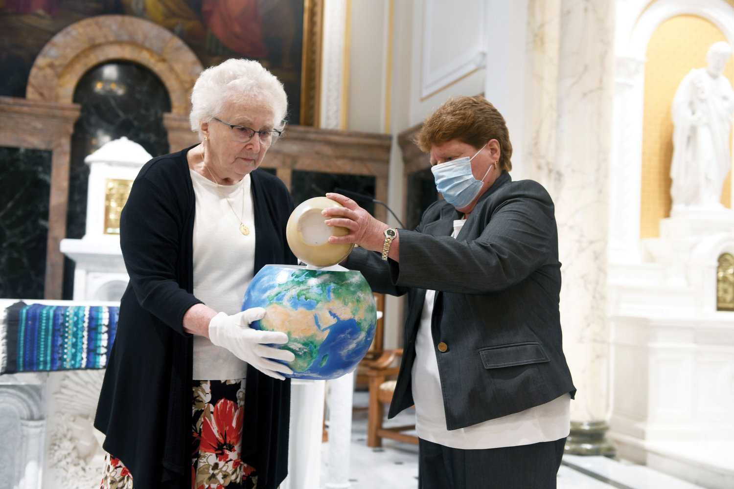 Sister Jean Flannelly, S.C., member of the LSAP committee, is holding the earth bowl with Maureen Reiser, director of associates.