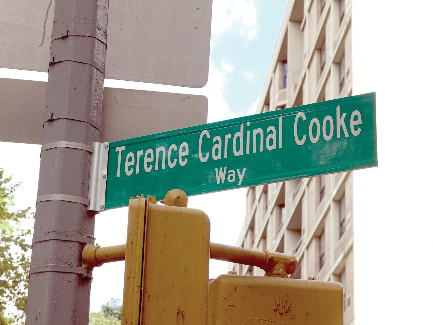 The street sign located at the corner of Fifth Avenue and 106th Street.