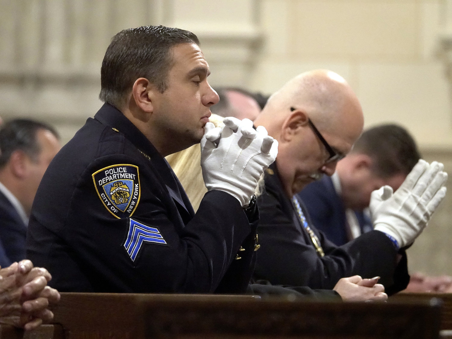 Members of the NYPD kneel in prayer during the Mass.