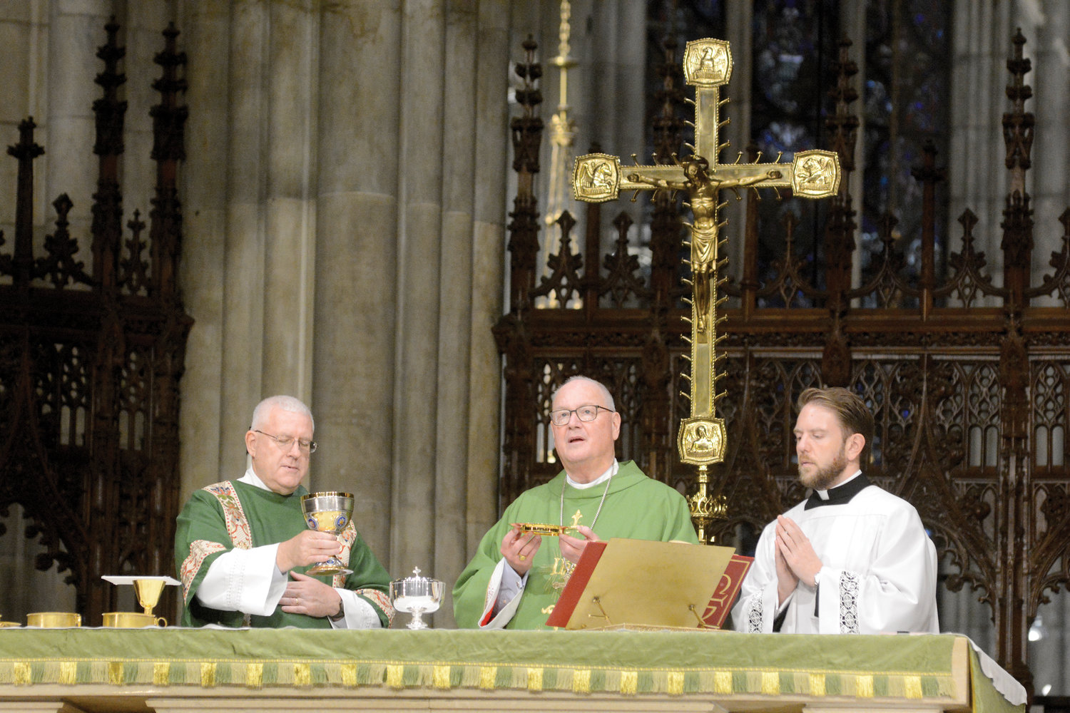 Deacon Maher holds the chalice at the altar.
