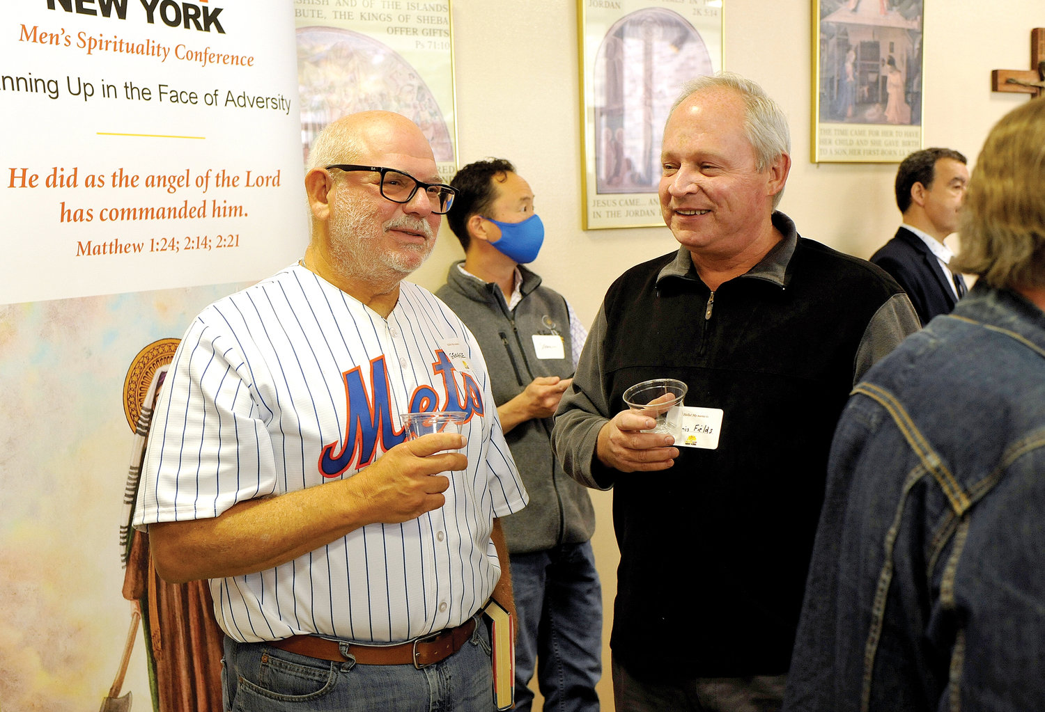 George Knapp of Holy Trinity parish in Poughkeepsie shows his allegiance to the New York Mets and speaker Mike Piazza at the ManUp New York men’s spirituality conference Oct. 23. With him is Chris Fields of St. Martin de Porres, Poughkeepsie.