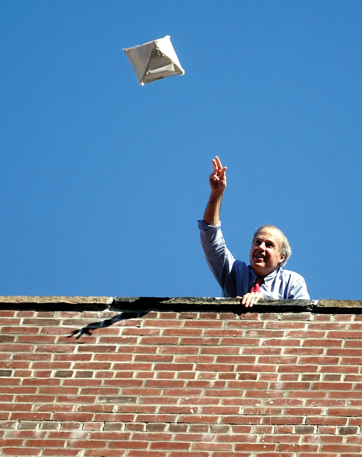 Science teacher William Hawthorn lofts a parachute and egg from the roof.