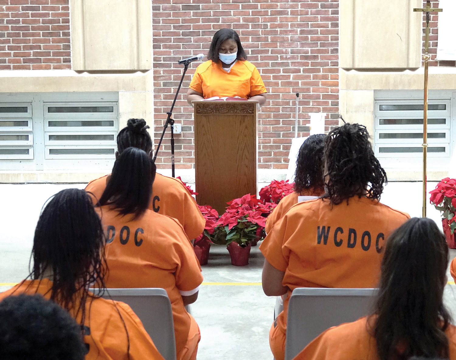 An inmate proclaims a reading at Mass.