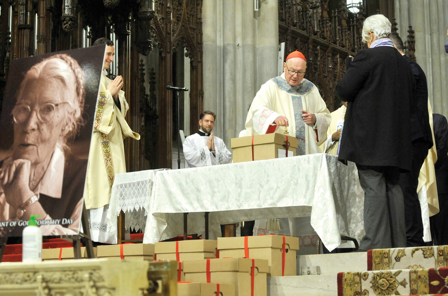 Cardinal Dolan stamps a heated wax seal atop a ribbon on a box, marking the conclusion of the diocesan phase of the canonization cause for Servant of God Dorothy Day during Mass Dec. 8 at St. Patrick’s Cathedral.