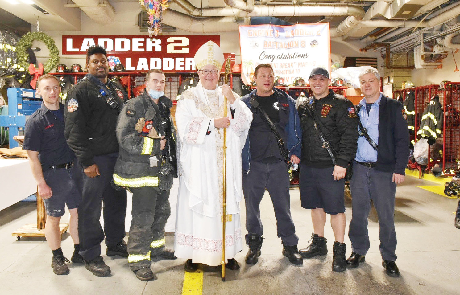 Cardinal Dolan greets members of the FDNY during his visit to Engine 8/Ladder 2/Battalion 8 on 51st Street between Lexington and Third avenues in Manhattan on Christmas Eve. The cardinal celebrated Mass for the firefighters and their family members, as well as those of EMS Command, Engines 65 and 21, and NYPD officers from the 17th Precinct.
