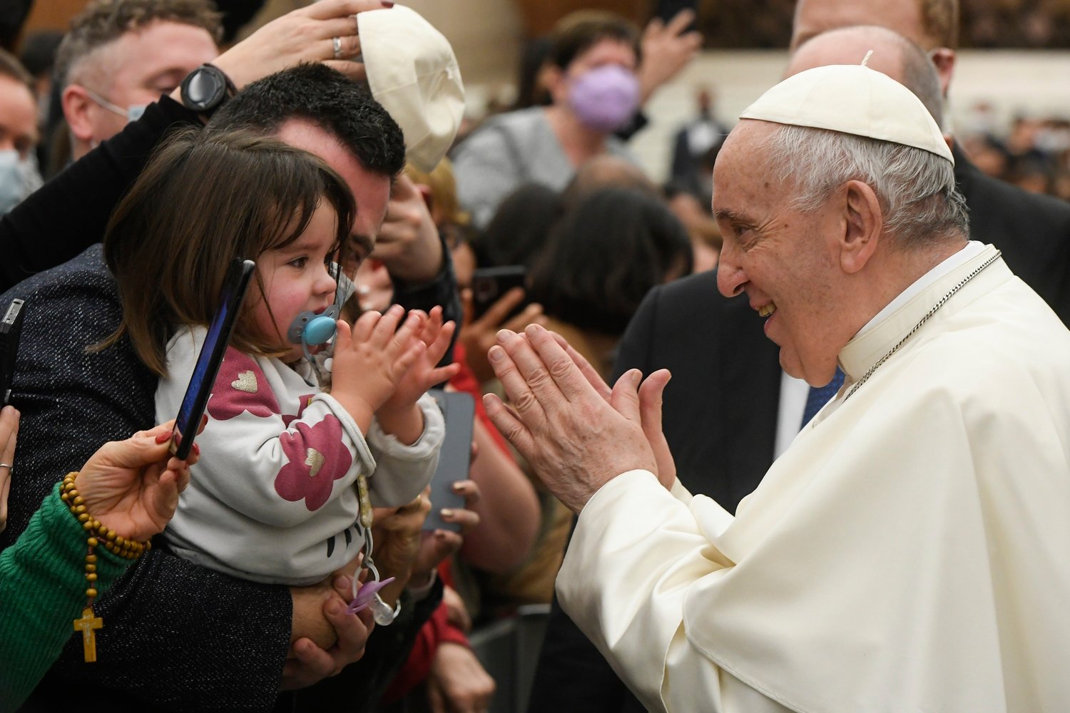 Pope Francis greets a young girl after his weekly general audience Dec. 29 in the Vatican’s Paul VI hall.