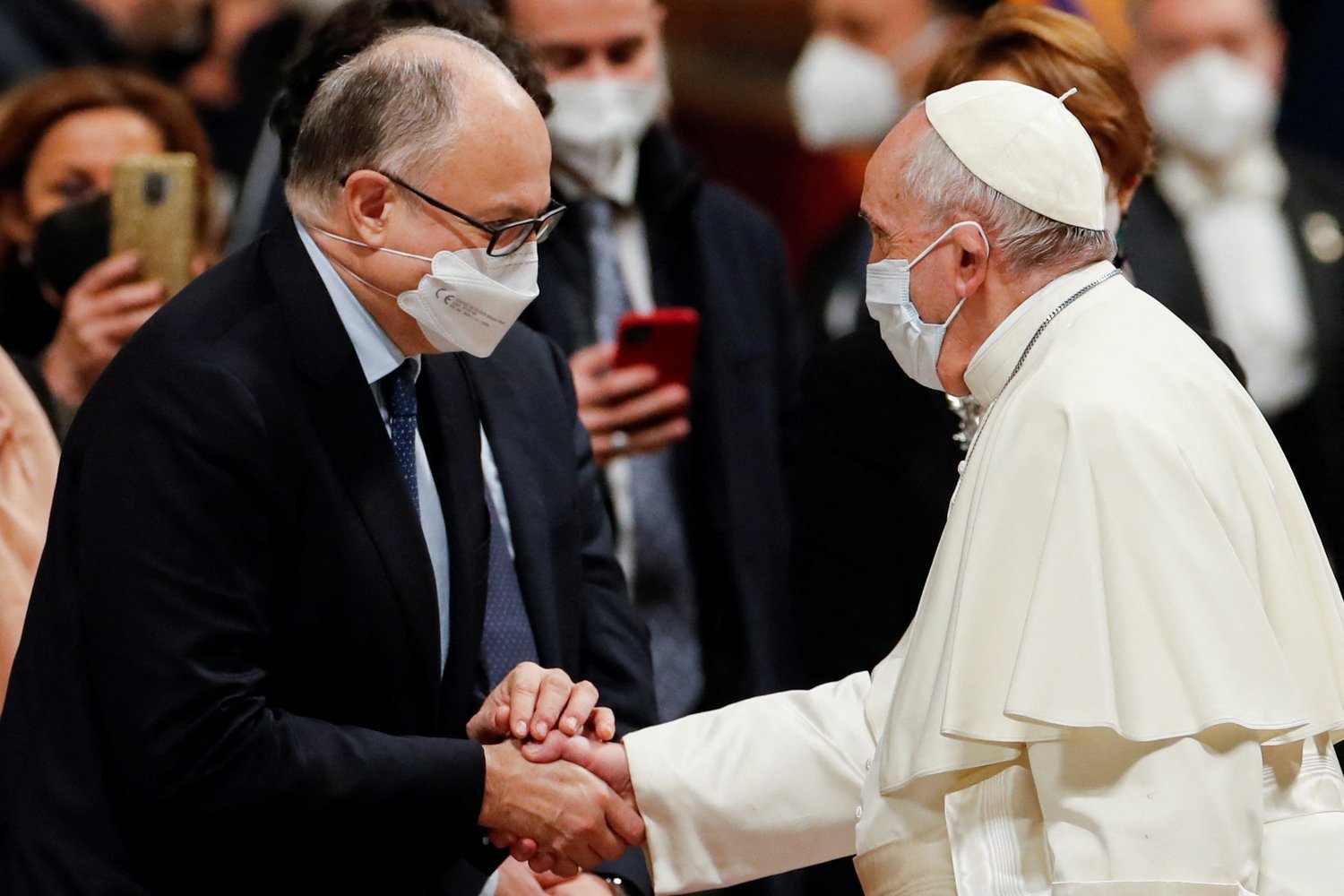 Pope Francis shakes hands with Rome’s new mayor, Roberto Gualtieri, as he arrives for an evening prayer service in St. Peter’s Basilica at the Vatican Dec. 31.