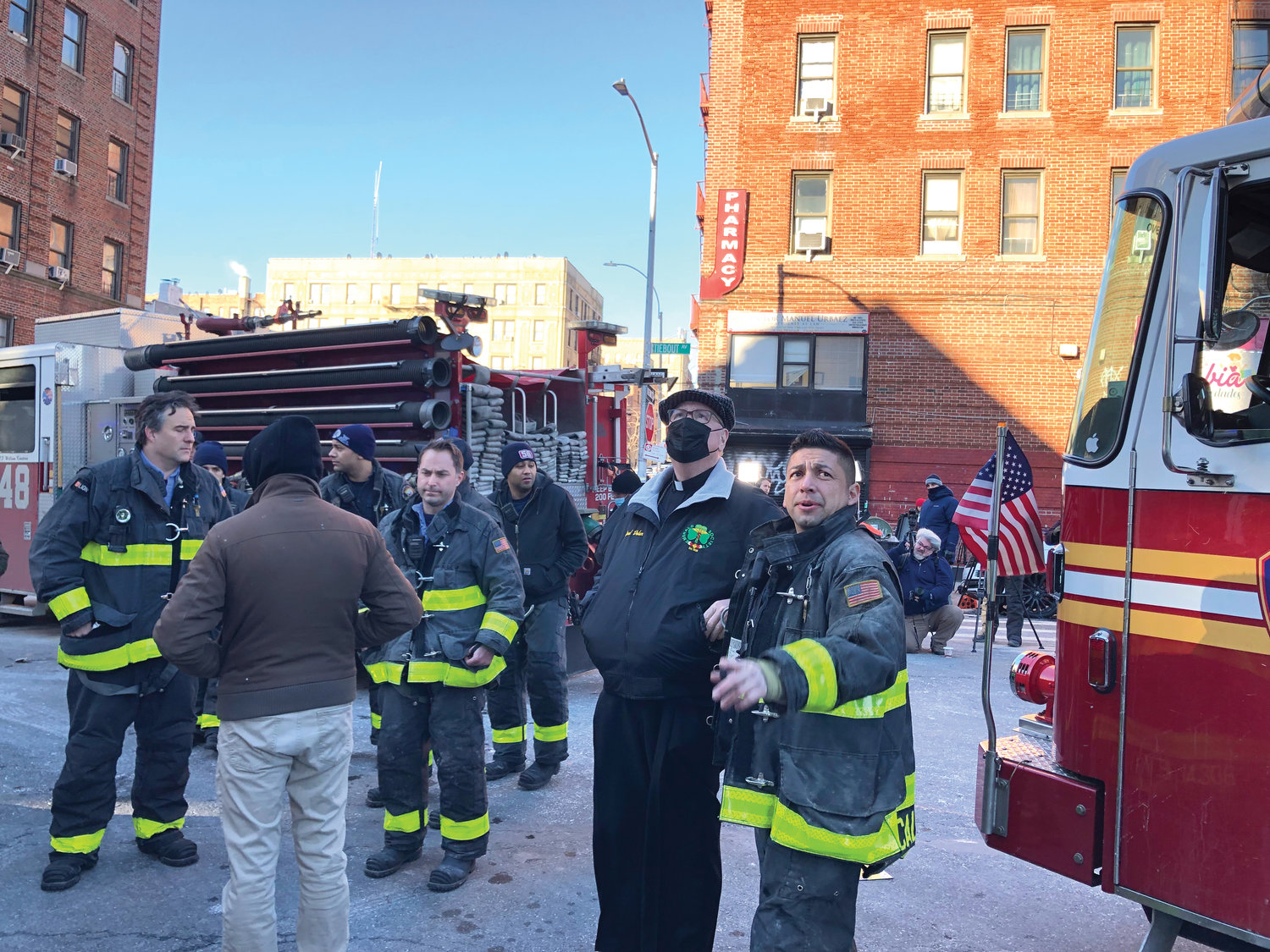 Cardinal Dolan looks over the scene with firefighters on the morning of Jan. 10.